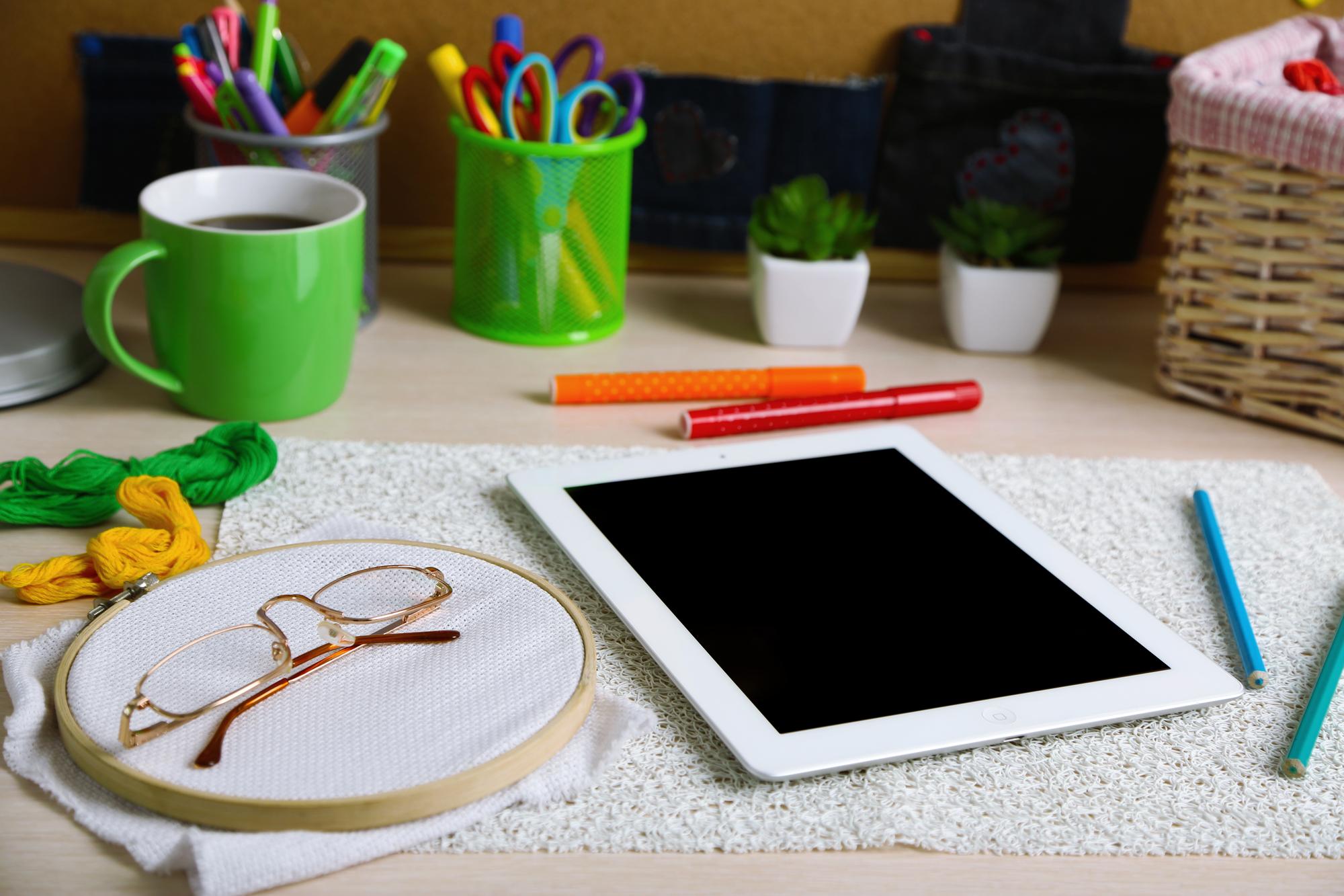 Studio table with embroidery hoop and digital tablet