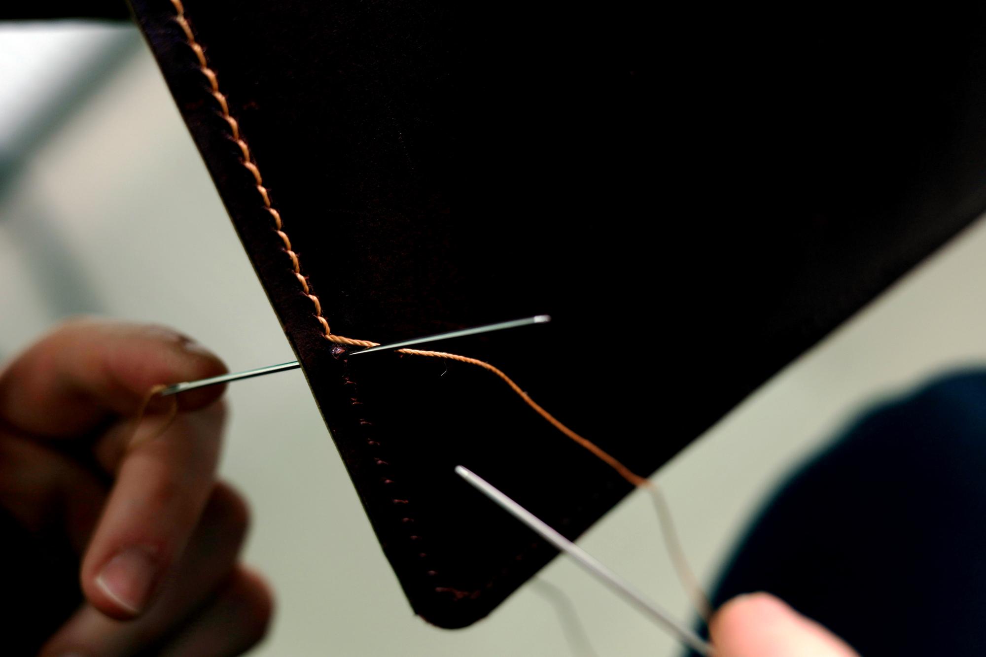 Hand finishing stitches under magnifier